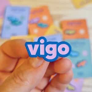 Pin Vigo Ciudad Olívica esmaltado con diseño original de Vaidhé. Disponible en varios colores. Ideal para decorar chaquetas, mochilas o regalar.