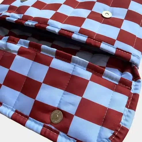 Funda acolchada para portátil con estampado geométrico azul y diseño rectangular.