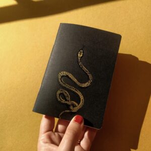 Libreta artesanal con cubierta roja e ilustración de una culebra. Perfecta para escribir o dibujar. Diseño original y encuadernación hecha a mano.