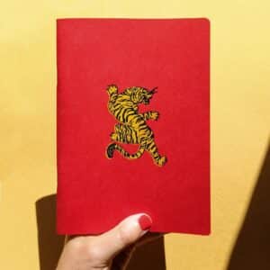Libreta artesanal con cubierta roja e ilustración de tigre. Perfecta para escribir, dibujar o journaling. Diseño original y encuadernación hecha a mano.